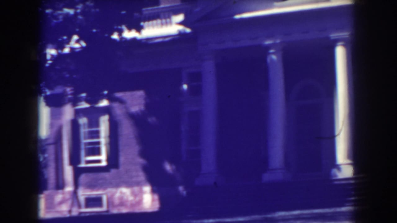 Atlantic City exterior frame from 1938 showing the columned front of a brick house with a shuttered window and arched entry.