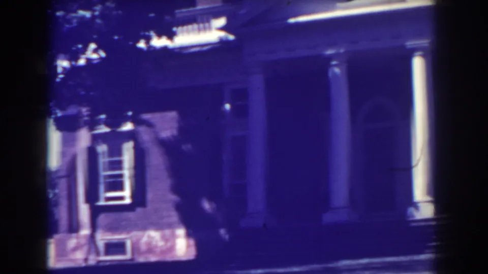 Atlantic City exterior frame from 1938 showing the columned front of a brick house with a shuttered window and arched entry.