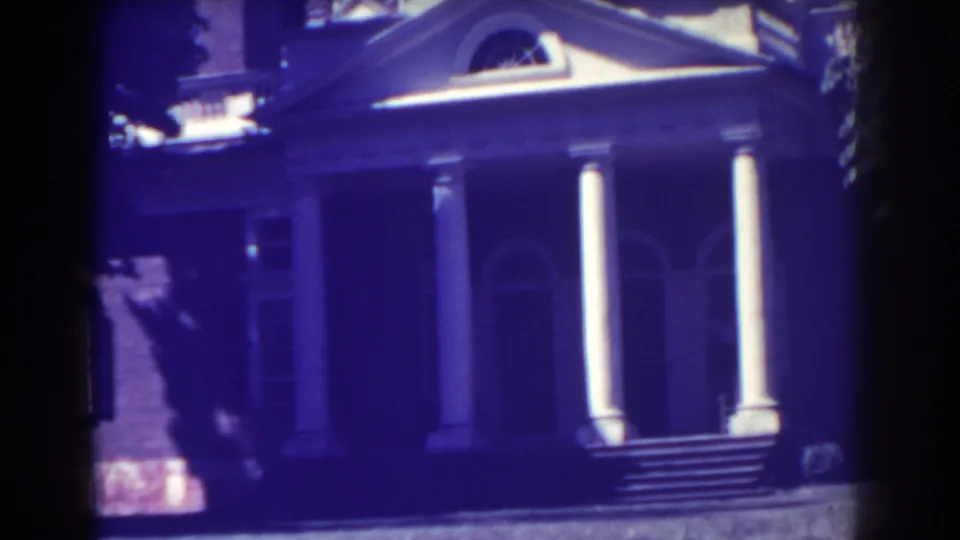 1938 frame of the stately Atlantic City house, showing front steps, tall white columns, brickwork, and an arched doorway.