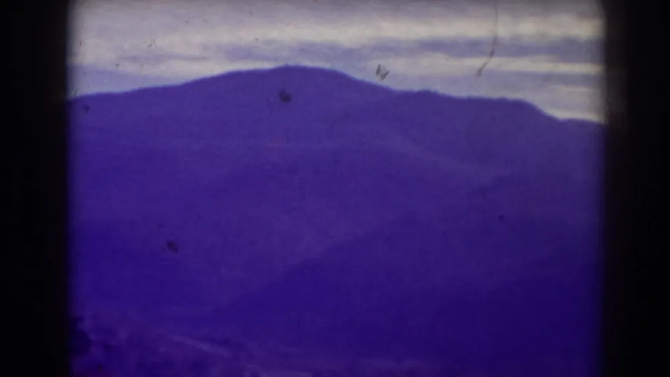 Blackwater Falls area mountain panorama in a 1938 8mm frame, with hazy ridges and visible film dust.