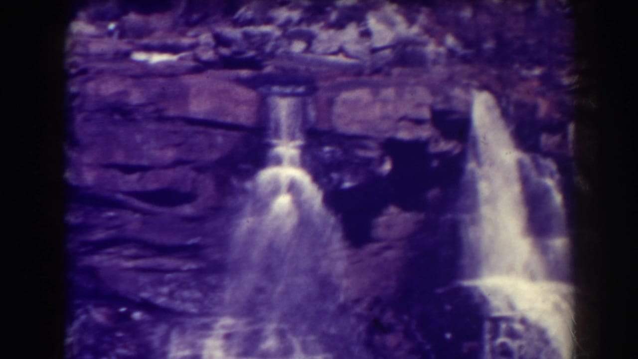 Two waterfalls appear across a rocky cliff face with bright spray.