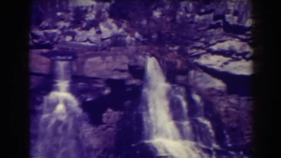 The home-movie frame shows a larger waterfall at right, a smaller fall at left, and layered rock at Blackwater Falls.