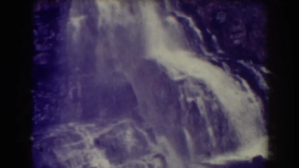 The final frame shows Blackwater Falls filling the view, with bright water, dark cliff texture, grain, and purple color shift from the 8mm scan.