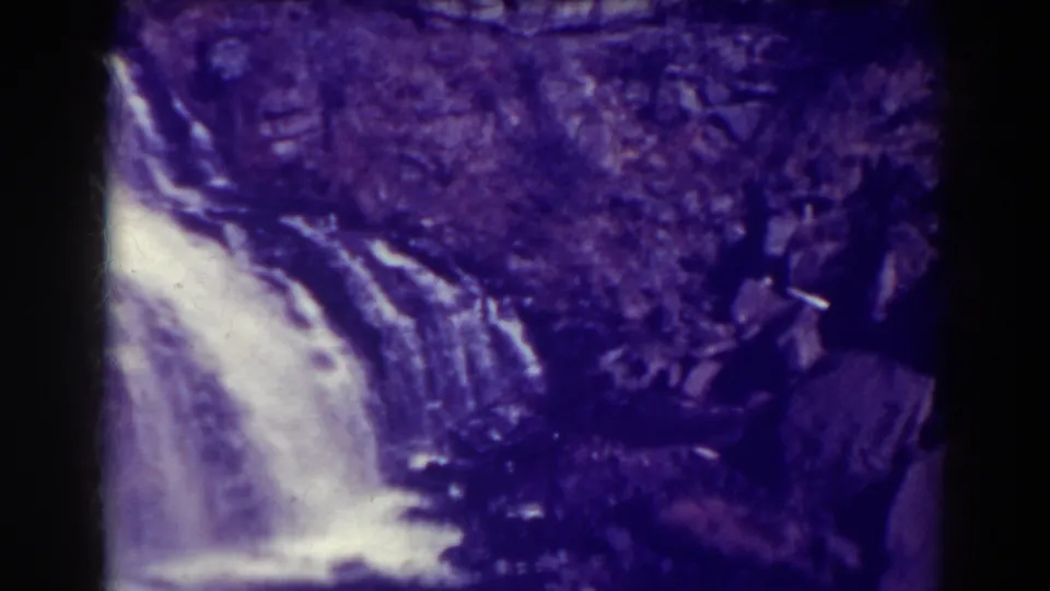 A visitor-shot 1938 frame shows Blackwater Falls dropping past layered rock, with soft focus, grain, and dark edge vignetting.