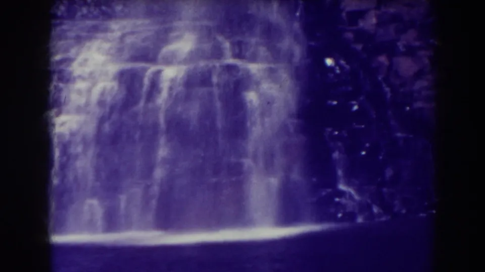 A close 1938 Blackwater Falls frame shows water dropping into a bright lower edge beside shadowed rock.