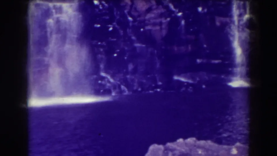 A 1938 8mm view of Blackwater Falls showing the main fall at left and a smaller side cascade against the rocky wall.