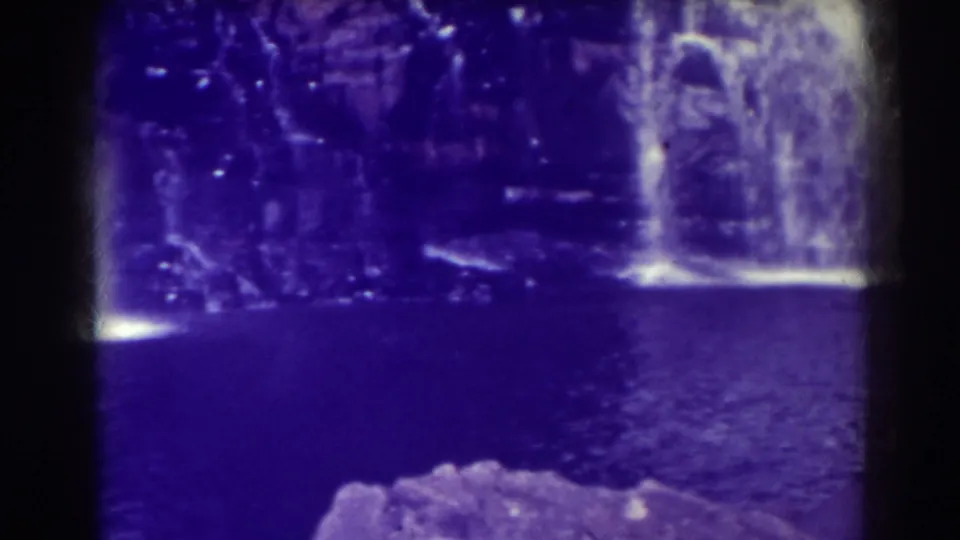 Blackwater Falls in West Virginia, shown from a visitor angle with a side cascade, dark pool, foreground rocks, and strong purple film shift.