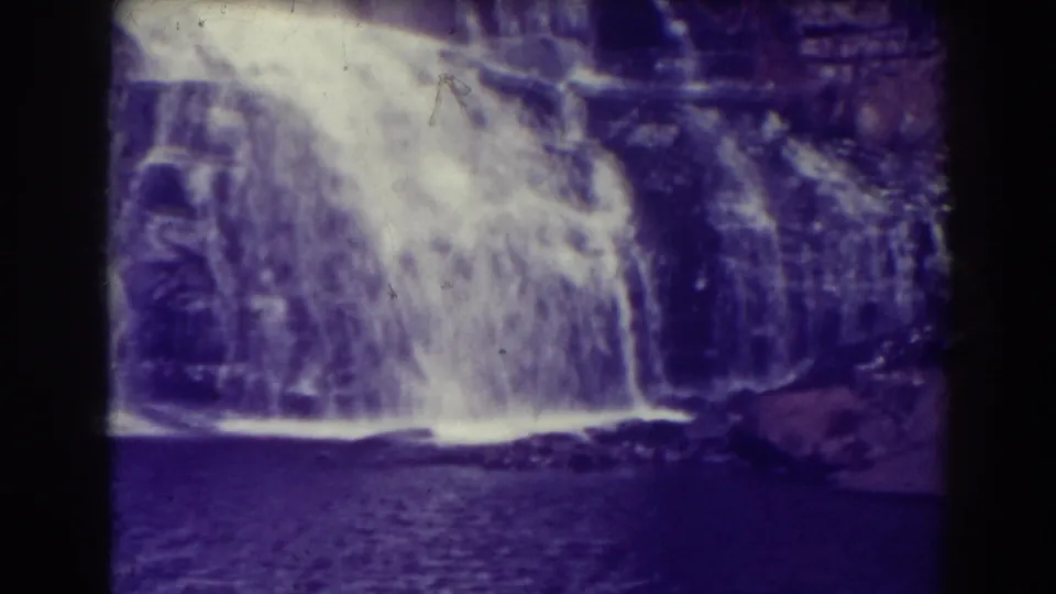 Closer 1938 home-movie view of Blackwater Falls, with white water dropping over layered rocks into rippled dark water below.