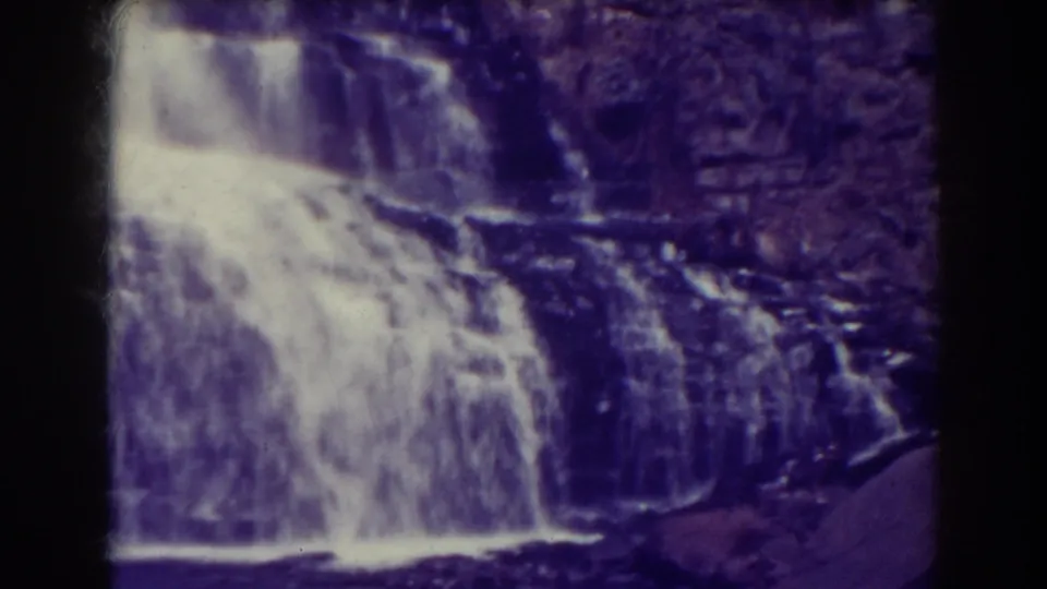 Angled 8mm frame of Blackwater Falls in 1938, showing whitewater spreading across a rocky drop toward the dark pool below.