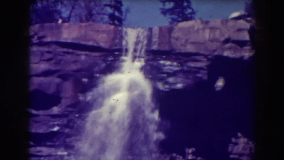 Late frame from the 1938 Blackwater Falls clip, with the cascade centered and dark film or foreground shadow on the right.