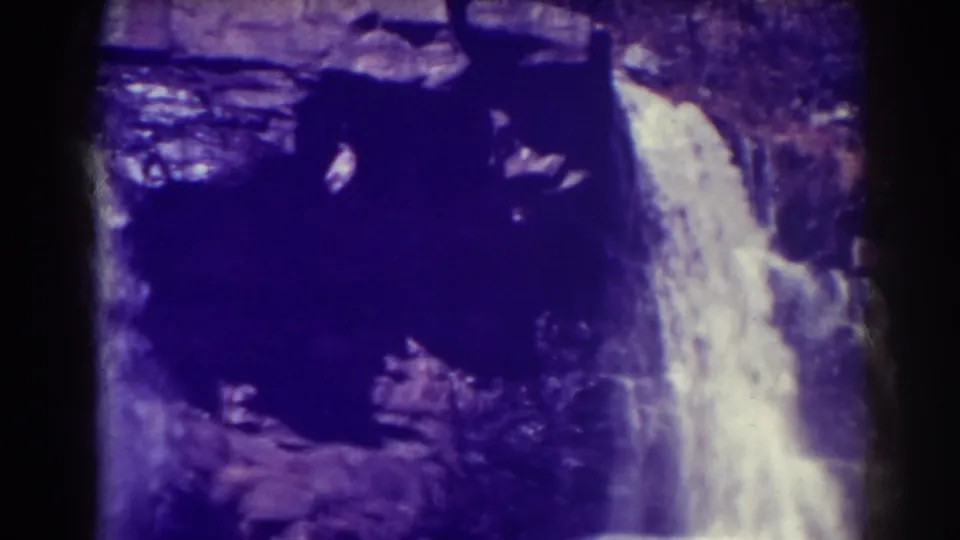 Blackwater Falls in a 1938 8mm frame, with a tall white cascade falling beside shadowed black rock and a narrow film edge.