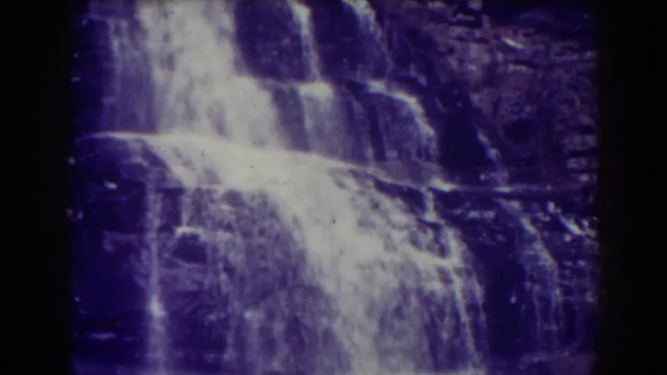 1938 home-movie view of Blackwater Falls showing water descending over broad, dark rock formations with visible grain.