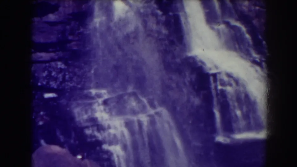Blackwater Falls fills the frame as water spreads across stepped rock, softened by 8mm grain, shadowed edges, and purple color shift.