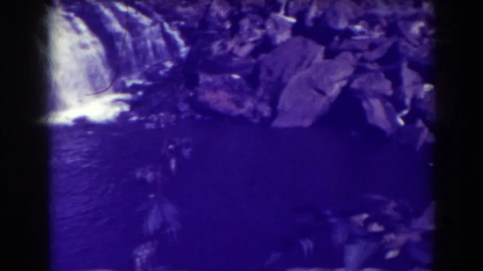 Blackwater Falls appears in a 1938 8mm frame, with cascading water, large rocks, dark river surface, and purple film cast.