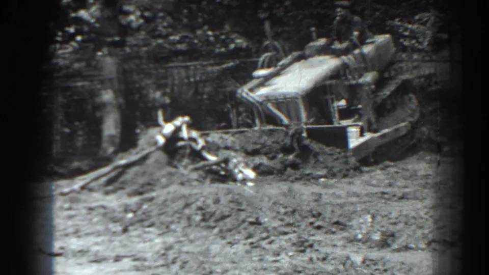 Home-movie view of a 1938 Cumberland worksite, with a tracked front-loader pushing soil across uneven ground.