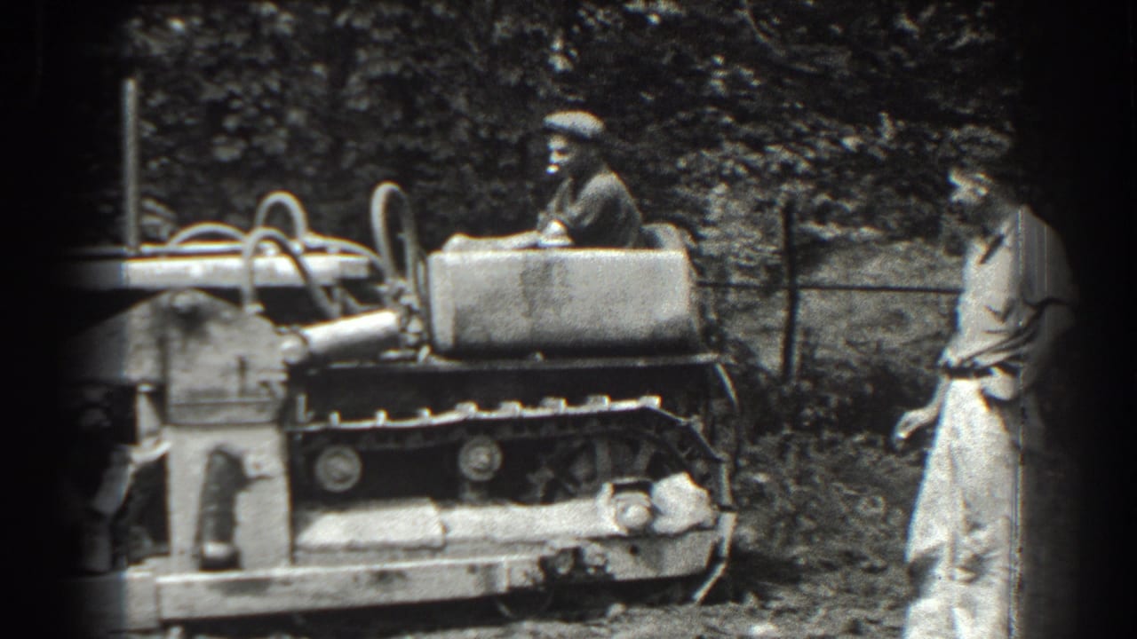 In Cumberland, Maryland, 1938, a man in a flat cap operates a tracked bulldozer while another man stands beside the rough ground.