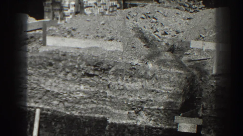 1938 Cumberland construction view with excavated earth, upright posts, rough planks, gravel piles, and a partial foundation edge.