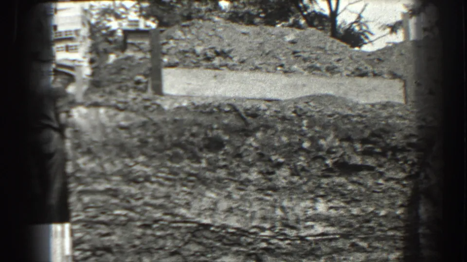 1938 Cumberland, Maryland view of a rough hillside excavation, with posts and partial structures visible near the upper edge.