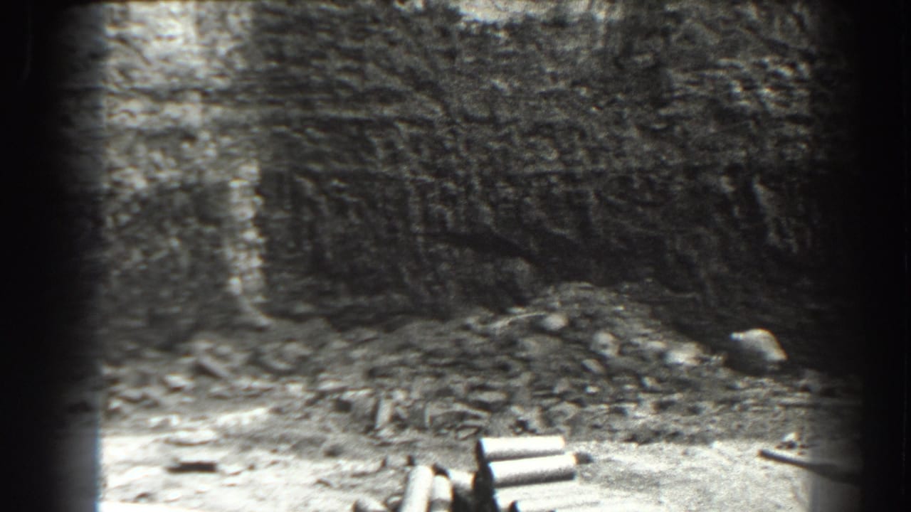 Deep excavation wall with rubble, loose materials, and dark 8mm frame edges.