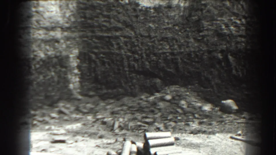 Cumberland, Maryland 1938 home-movie frame showing a deep excavation face, scattered rubble, and construction materials near the pit edge.