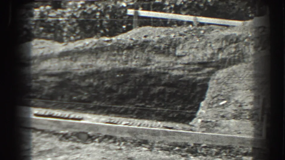 Cumberland, Maryland 1938 frame showing the street-side edge of the foundation excavation, with curb drainage and a raised dirt bank.