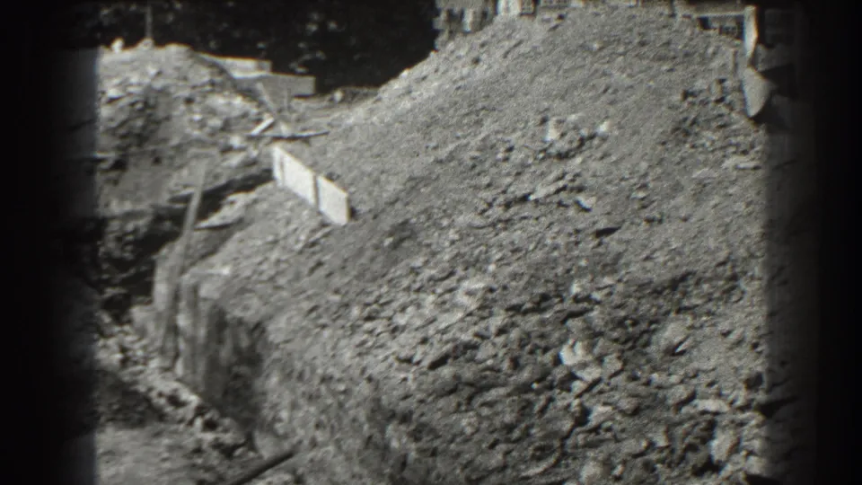 1938 Cumberland, Maryland frame showing a wider view of the excavation, with timber formwork, steep dirt banks, and debris on the ground.