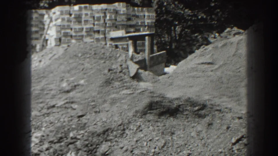 A Cumberland construction scene shows a large dirt mound, block stacks, and part of a small earthmoving machine near a building.