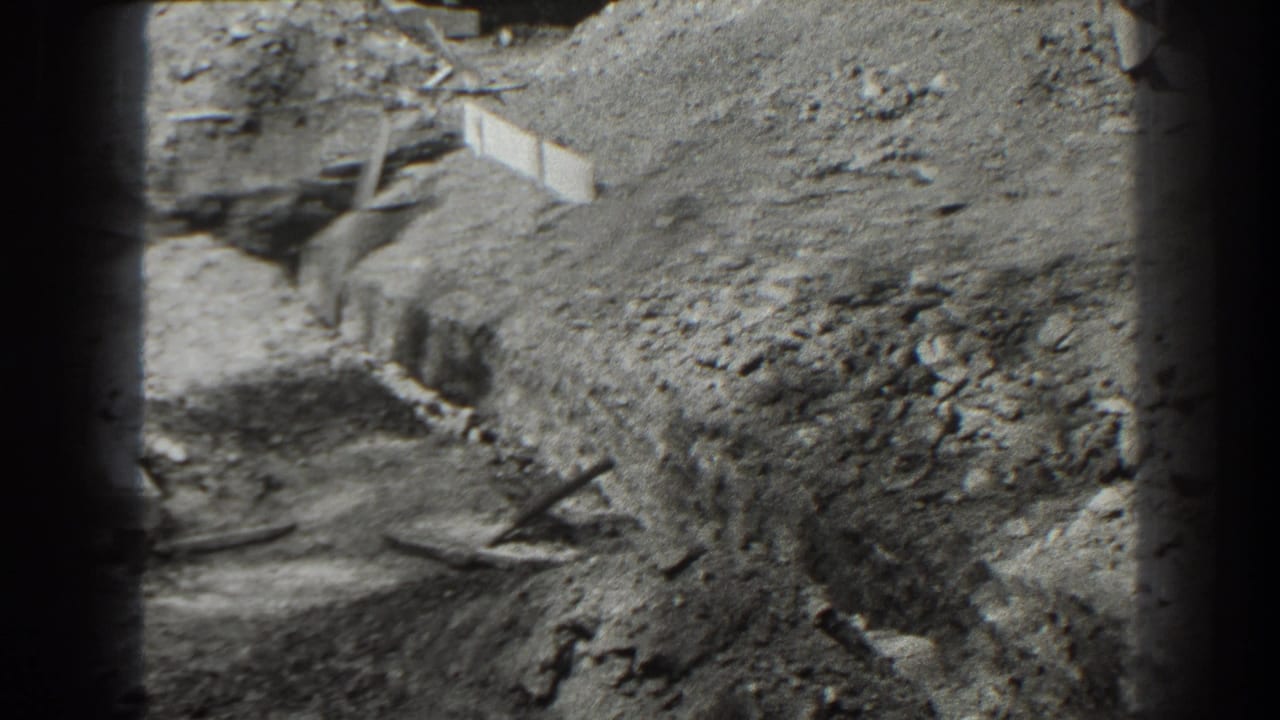 Excavated ground and large dirt mound at a construction site.