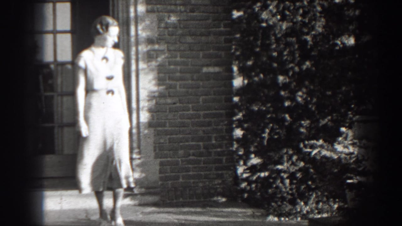Woman in a light dress stands near steps outside a brick building.