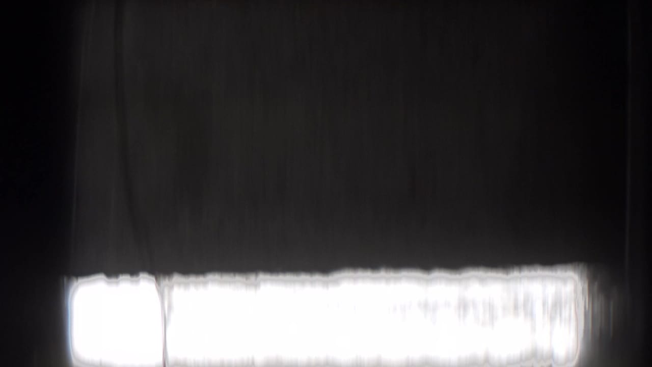 Dark exposed 8mm film with a bright overexposed band near the lower edge.