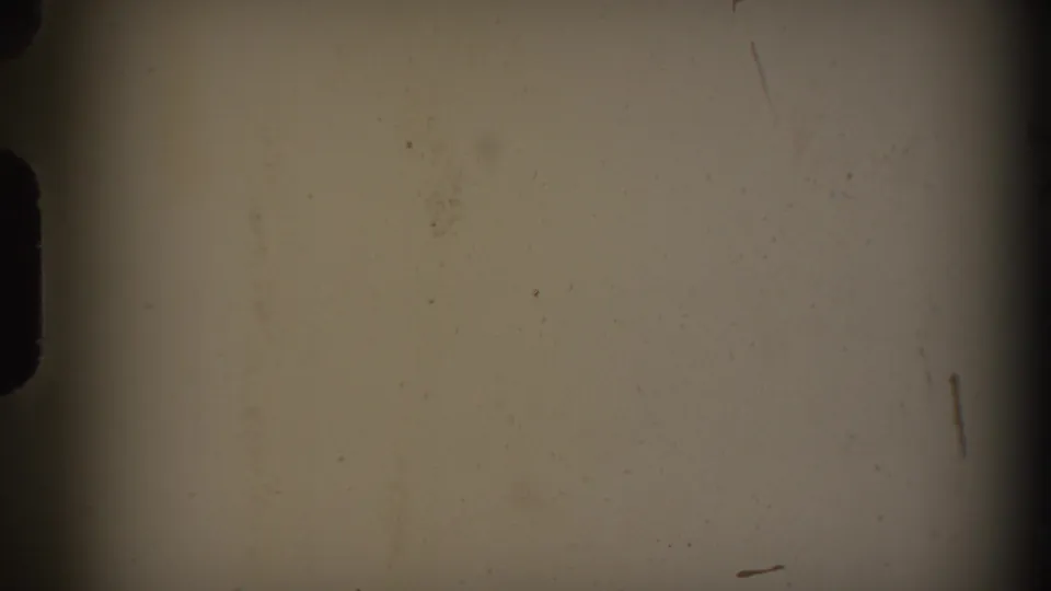 Pale 8mm film frame from the 1938 Cumberland reel, showing dust marks, scratches, and darkened frame edges.
