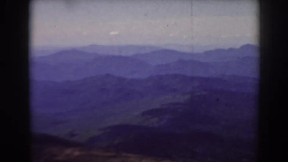 Early color 8mm frame from Mount Washington with layered New Hampshire mountains, haze, and a darker foreground ridge.