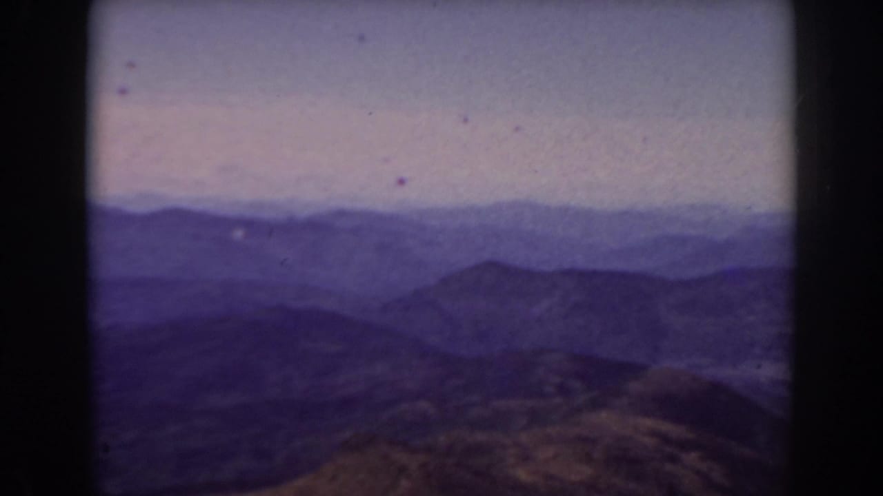 Distant mountain range and hazy sky seen through a dark film gate.