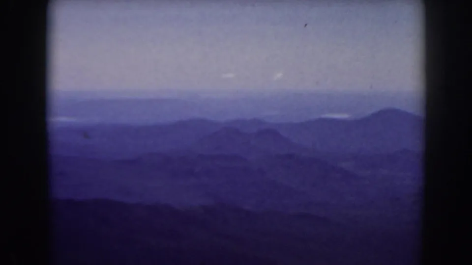1938 New Hampshire mountain landscape from Mount Washington, with layered blue ridges and a pale hazy sky in soft 8mm color.