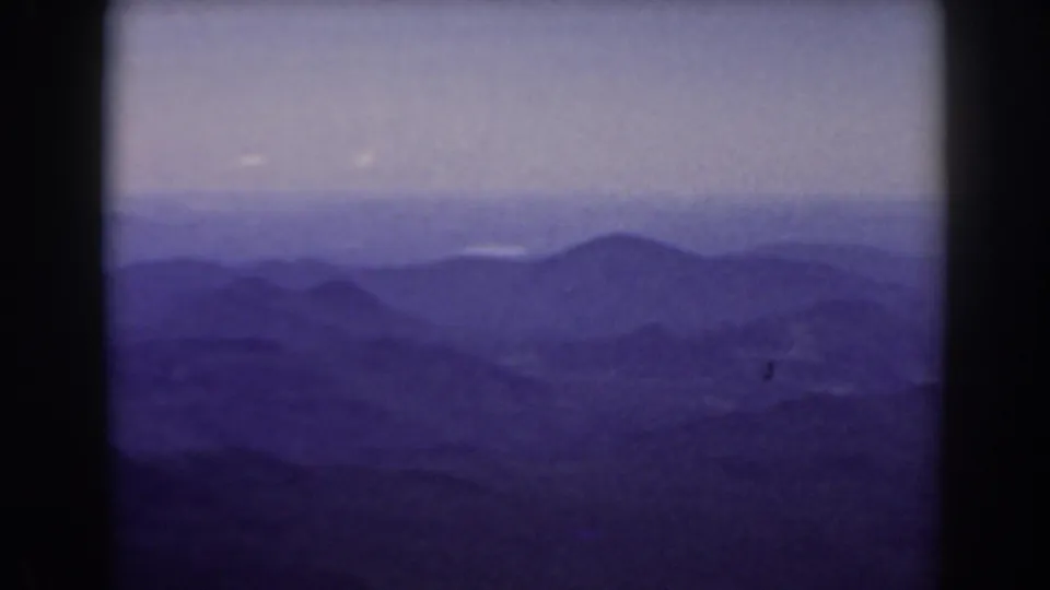 1938 Mount Washington-area view of distant mountain ridges fading into haze beneath a pale sky.