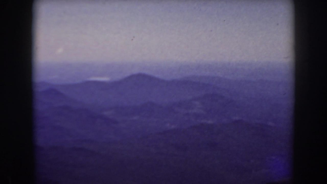 Distant mountain landscape with a soft horizon and blue-purple film tint.