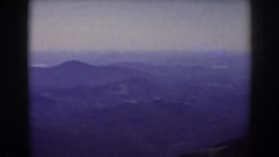 Mount Washington-area mountain view with low-contrast ridges, distant haze, and visible 8mm frame edges.