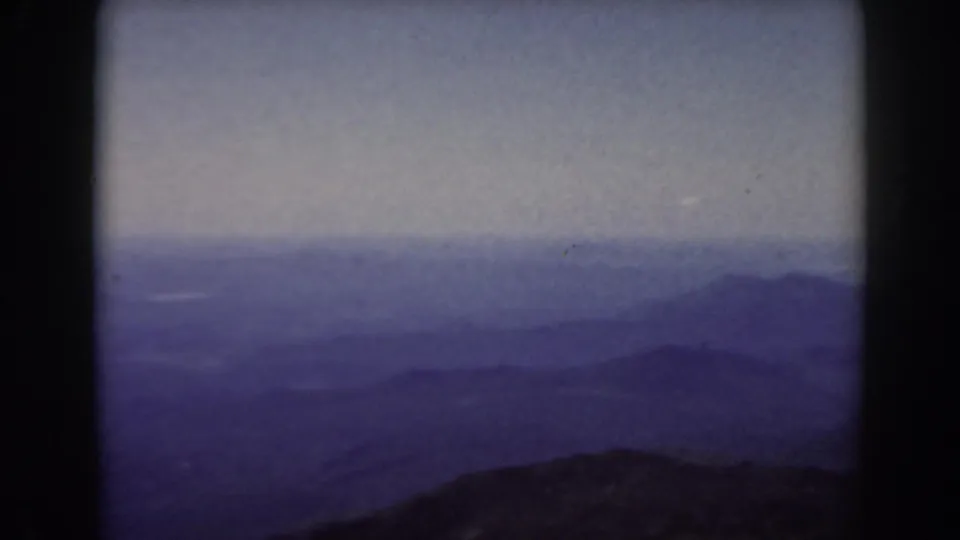 1938 Mount Washington 8mm frame with layered mountain ridges and haze across the New Hampshire landscape.