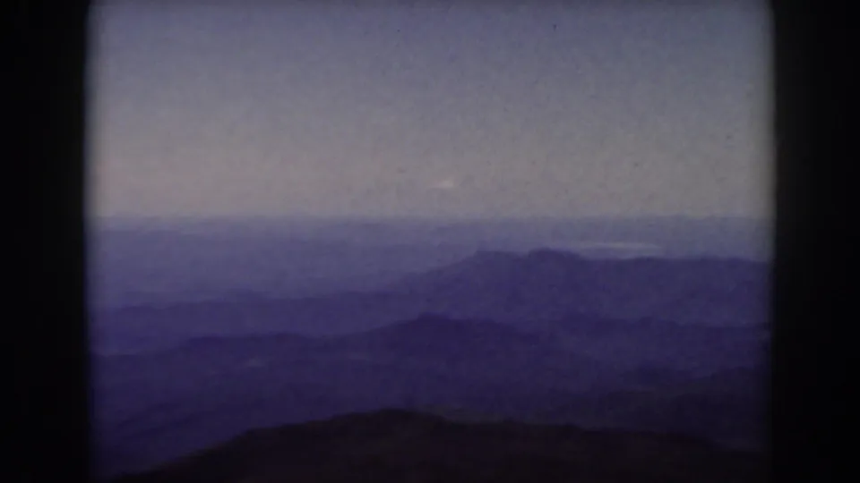 Vintage 8mm Mount Washington view showing hazy New Hampshire mountain ranges beneath a muted sky.