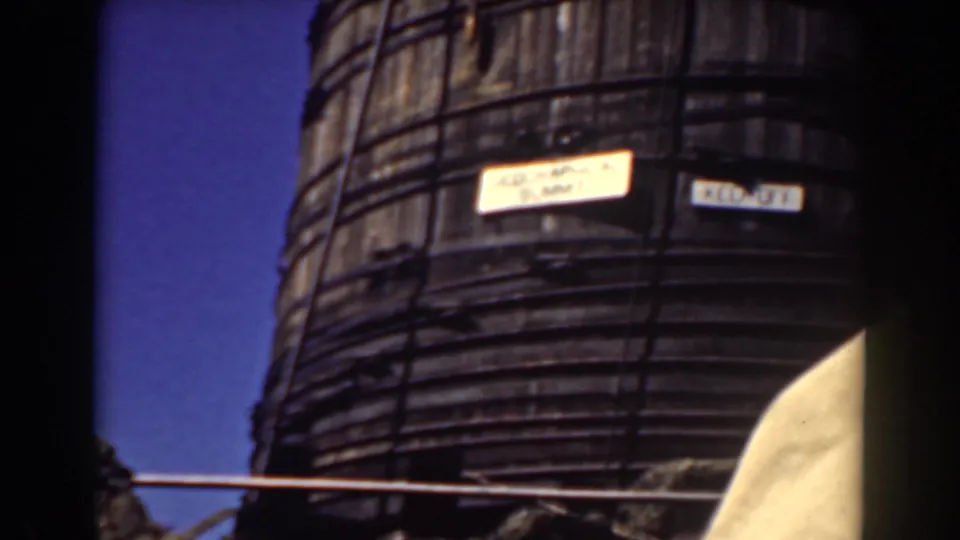 Close view of the weathered tower side with small signs, including a partially legible summit label.