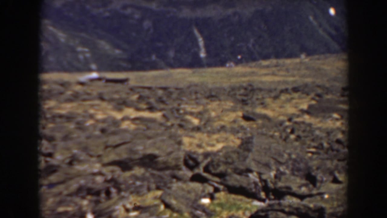 Distant mountain landscape seen across uneven rocky ground.