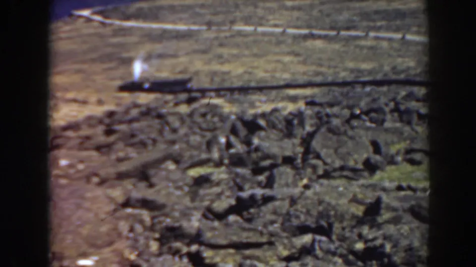 1938 Mount Washington frame showing a small train and white smoke plume on a rail line across the rugged hillside.