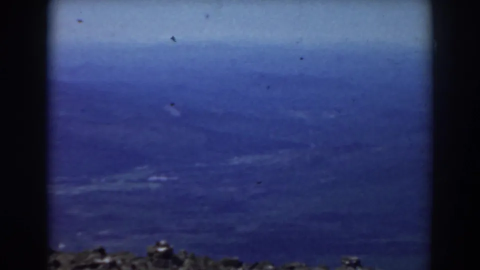 1938 Mount Washington home-movie frame showing mostly dark blue sky with a narrow rocky foreground at the bottom.