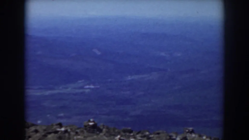 1938 Mount Washington home-movie view of distant hazy mountain ridges from a dark rocky summit ledge.