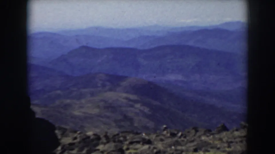Hazy mountain panorama from Mount Washington in 1938, framed by dark film edges and rocky summit terrain.
