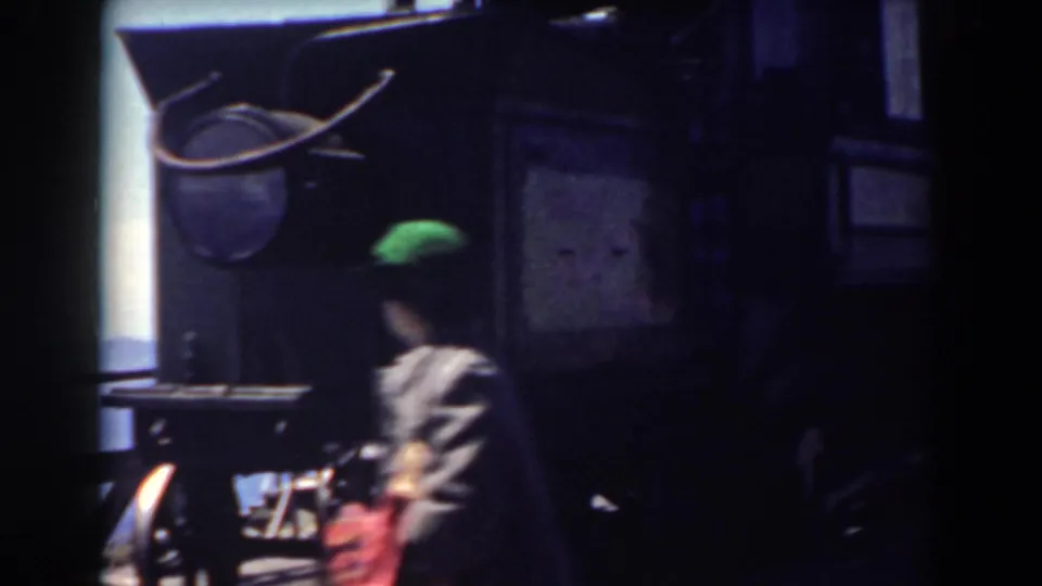 Person wearing a green hat walks past the Mount Washington observation tower area in 1938 home-movie footage.