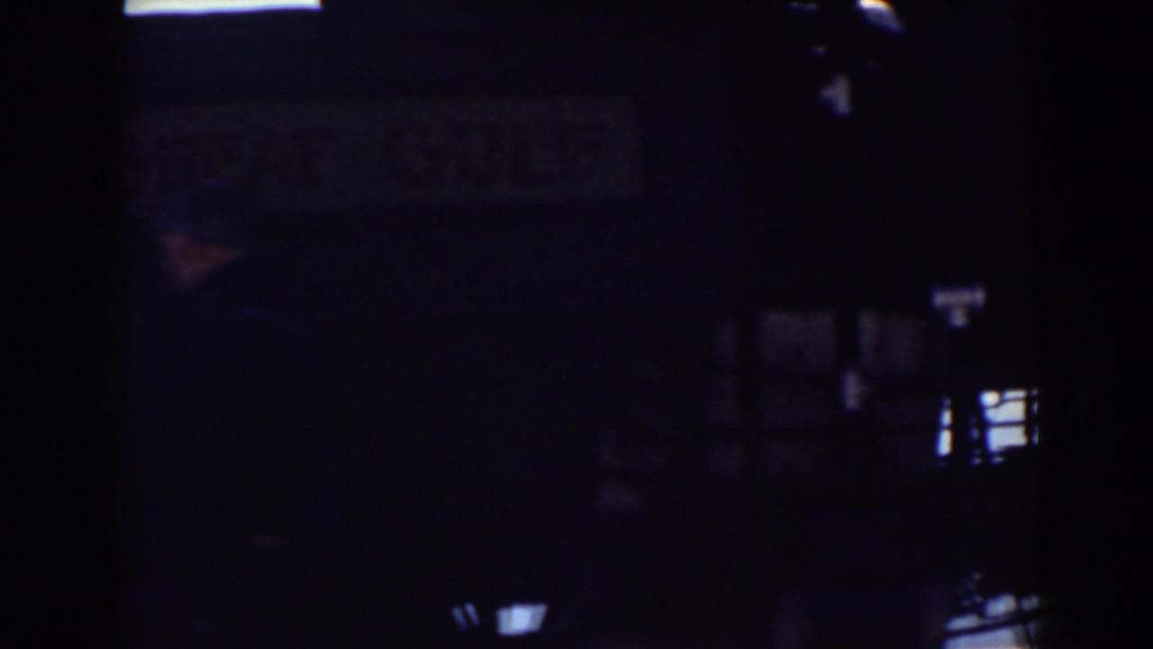 Dark view of a train side or station area with small bright openings.