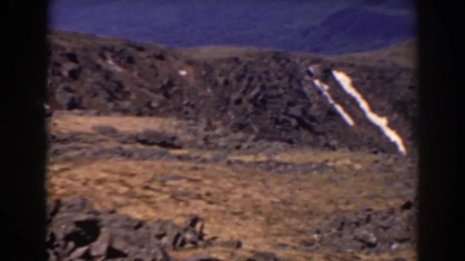 1938 Mount Washington landscape frame with rough brown terrain and a narrow diagonal snow patch on the rocky slope.