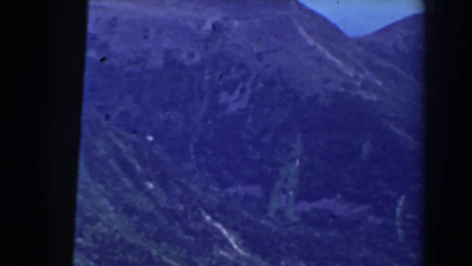 Blue-shifted 8mm frame of the Mount Washington area, with layered mountain slopes and a pale snow trace in the valley terrain.