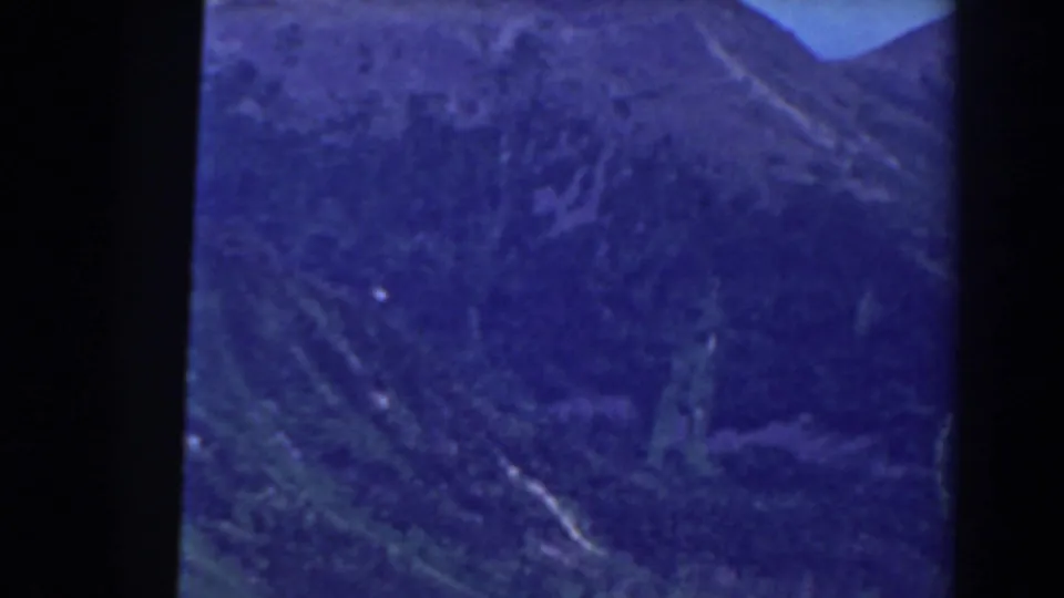 Late-1930s home-movie frame of Mount Washington terrain, showing steep blue-tinted slopes, valley detail, and heavy film-frame edging.